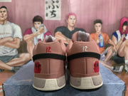 Rear view of the matching pink sneaker pair showing black heel bands, red and white heel details, and speckled midsoles.