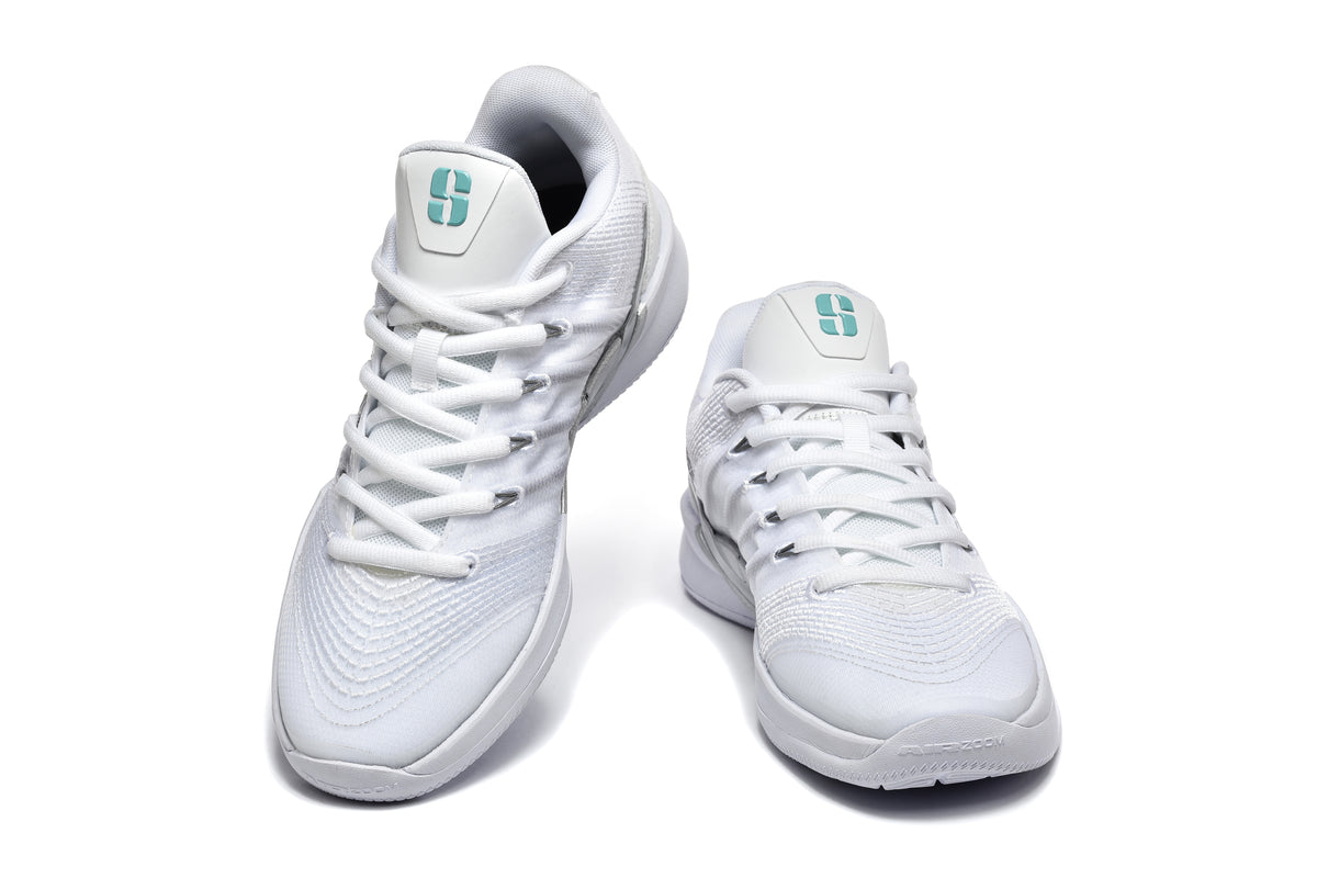 Pair of white low-top basketball shoes viewed from the front, with teal tongue logos and white laces