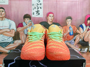Front view of the orange Nike sneakers showing the textured toe boxes, tan tongues, and mint-green laces.