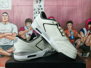 White and black low-top sneakers shown from a three-quarter side angle, with layered panels and a visible heel cushioning unit.