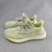 Pair of pale green knit low-top sneakers shown from a three-quarter angle.