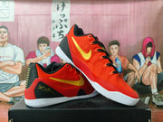 Angled view of red Nike basketball sneakers with gold Swoosh branding, black laces, black heel panels, and white outsoles.