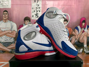 Pair of white, blue, and red Nike high-top basketball sneakers shown from an angled side view.