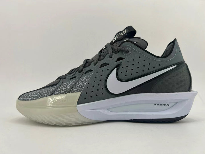Side view of a dark gray Nike basketball shoe with a white Swoosh, pale forefoot section, and ZoomX midsole marking