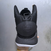Rear view of the black high-top sneaker showing the padded heel panel and white outsole edge.