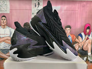 Angled view showing the black layered upper, purple panels, and white outsole.