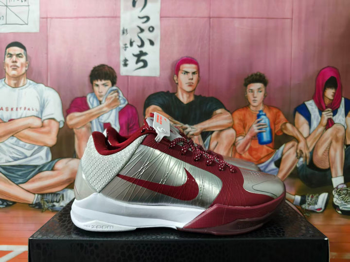 Side view of burgundy and silver Nike basketball shoes with a white outsole