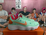 Side profile of a mint green Nike sneaker with an orange Swoosh, orange heel detail, red trim, and dotted overlays.