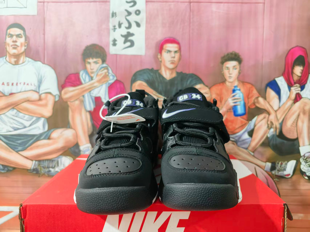 Front view of black Nike Air sneakers with white Swoosh accents, purple tongue detailing, perforated toe panels, and a Nike shoebox.