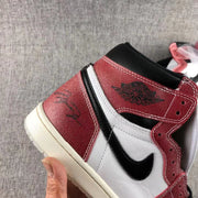 Side close-up showing the black Swoosh, white mid-panel and red ankle overlay.