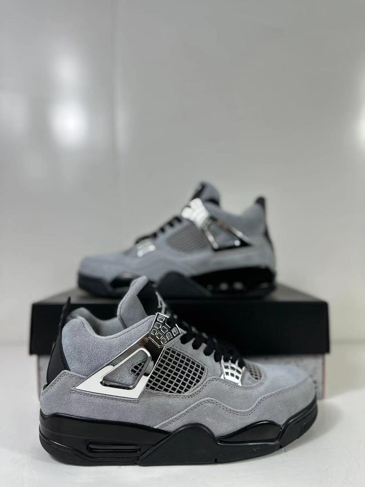 Pair of gray and black Air Jordan 4 Retro sneakers shown from a side angle with silver-tone lace hardware.