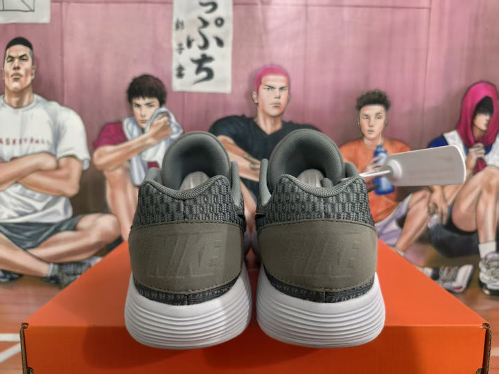 Rear view of grey and black Nike KD basketball sneakers showing padded collars, heel panels, and white sculpted outsoles.