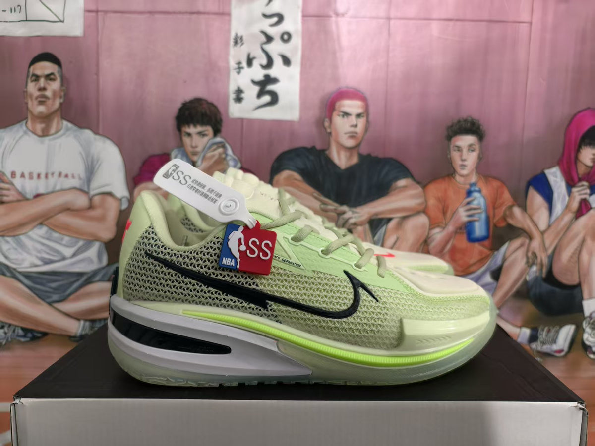 Side view of light green Nike GT basketball sneakers showing the mesh upper, black Swoosh, layered midsole, and product hangtags.
