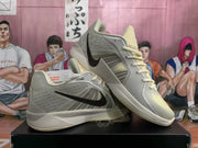 Nike Kobe basketball shoes shown at an angle, highlighting the gray and pale yellow colorway