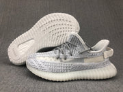 White and grey sneaker pair shown with one outsole facing upward; adidas branding is visible on the outsole.