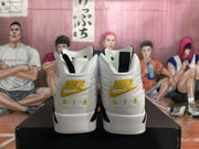Rear view of white high-top sneakers with yellow Nike Air branding