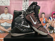 Angled view of the pair highlighting the white Swoosh logos, graphic side panels, woven forefoot sections, and layered high-top construction.