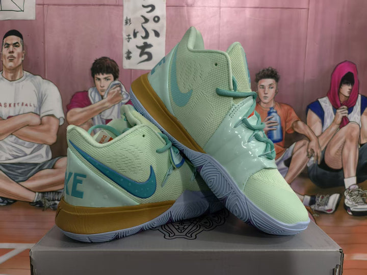 Pair of mint green Nike basketball sneakers with blue accents and gold-toned midsoles displayed on a box.