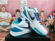 Angled view of Nike Kobe basketball shoes showing blue Swoosh details, patterned laces, and teal accents.