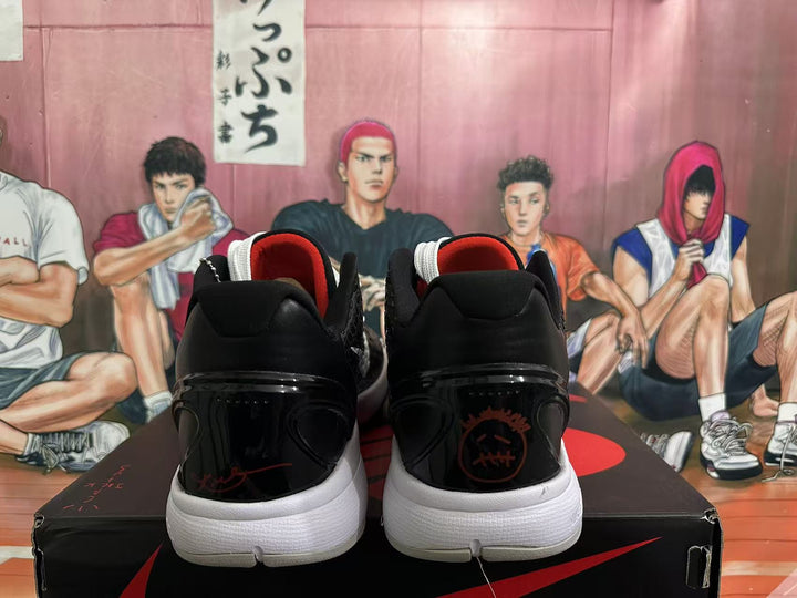 Rear view of black and white Nike basketball sneakers with red inner collars on a shoebox.