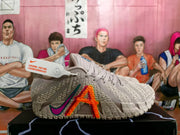 Side view of a light pinkish-gray Nike Kyrie shoe with bright multicolor graphics and a patterned outsole
