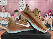Pair of brown Nike low-top sneakers shown at an angle, with white side Swooshes and mint-tone sole details.