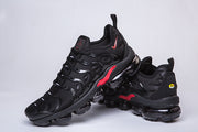 Black and red sneakers showing the side overlays and outsole pods.