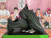 Two black and dark green sneakers arranged to show the side panels, green accents, lace area, and segmented soles.