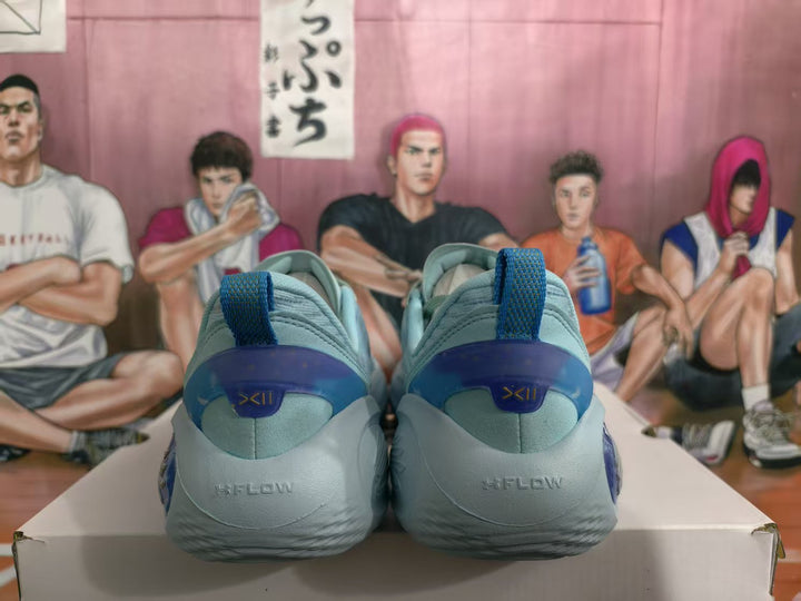 Rear view of a pair of light blue and blue sneakers showing padded collars, blue pull tabs, and heel branding.