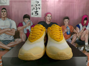 Front view of yellow and cream Nike basketball shoes with matching yellow laces.
