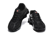 Top-front view of black Nike Shox Ride 2 sneakers with matching laces and red-and-white tongue accents.