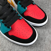 Close-up of the red perforated toe box, black toe overlay and teal lace panel.