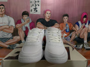 Front view of white Nike low-top sneakers showing flat laces, perforated toe areas, and padded collars.