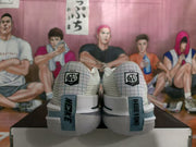 Rear view of white and silver Nike basketball shoes positioned on a shoebox.