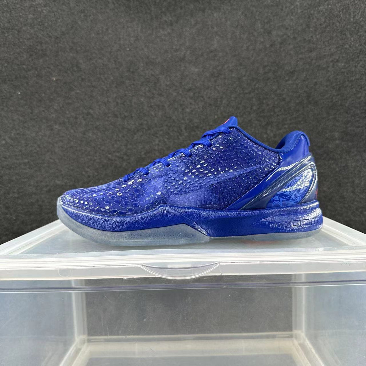 Side view of a blue Nike Kobe 6-style low-top basketball shoe with patterned upper and translucent-looking outsole