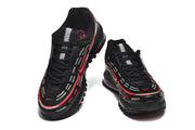 Top view of a pair of black sneakers with red and silver accents.