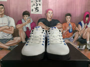Front view of the pair showing white mesh uppers, white laces, blue eyelet accents and black outsoles.
