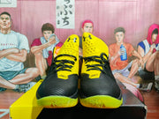 Front view of black and yellow high-top basketball sneakers with Under Armour tongue logos, black laces, and SC markings.
