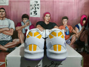 Rear view of white sneakers with yellow heel accents, purple outsoles, and black-and-purple detailing.