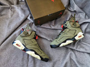 Pair of olive high-top sneakers displayed beside a black Jordan shoebox.