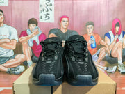 Front view of the black sneakers showing laces and mesh uppers