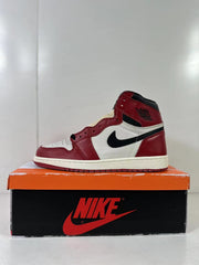 Side profile of one red, white, and black high-top sneaker on an orange shoebox.