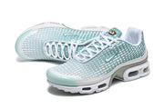 Pair of teal and white Nike Air Max Plus VII sneakers in an angled view.