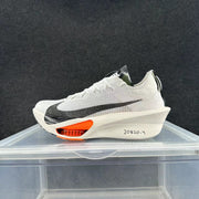 Side view of a white Nike Alphafly 3 running shoe with a black Swoosh, off-white sculpted midsole and orange forefoot detail.