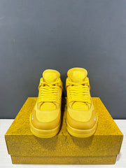 Front view of the yellow sneaker pair showing the laces, tongues, toe panels, and small white forefoot marks.