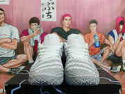 Front view of grey and white basketball shoes showing the laces and patterned toe panels.