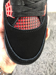 Top-down close-up of the black toe box, black laces, and red mesh panel.