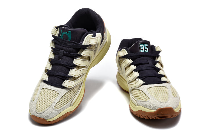 Front view of beige and black KD basketball sneakers with a gum-brown outsole; size 35 is visible on the tongue of one shoe.
