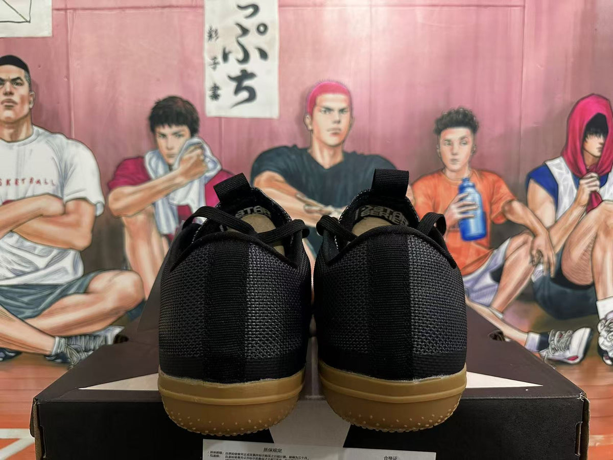 Rear view of black low-top sneakers with gum-colored outsoles