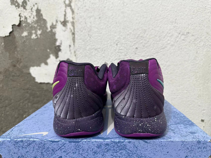 Rear view of purple Nike basketball shoes with dark stitched heel panels and speckled midsoles